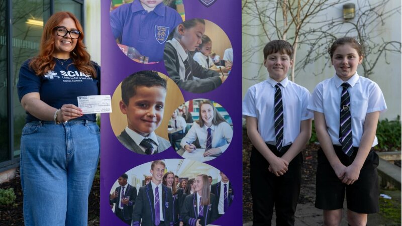 Jenna Fulton holdiing a cheque with two schoolchildren, standing in front of a banner.