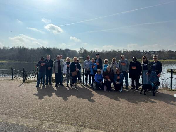 A group of walkers in front of a loch
